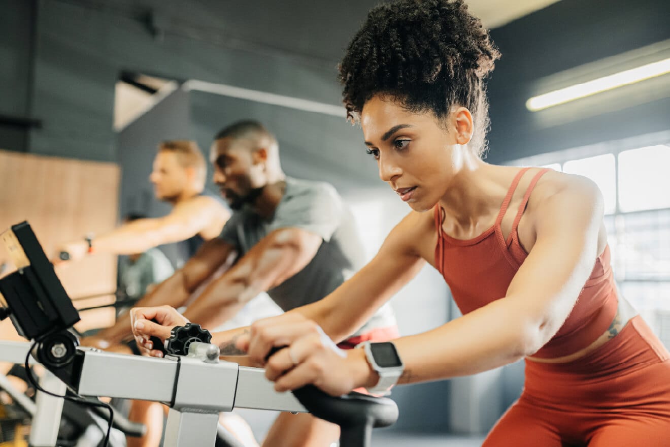 A woman running on a treadmill inside of a gym. 