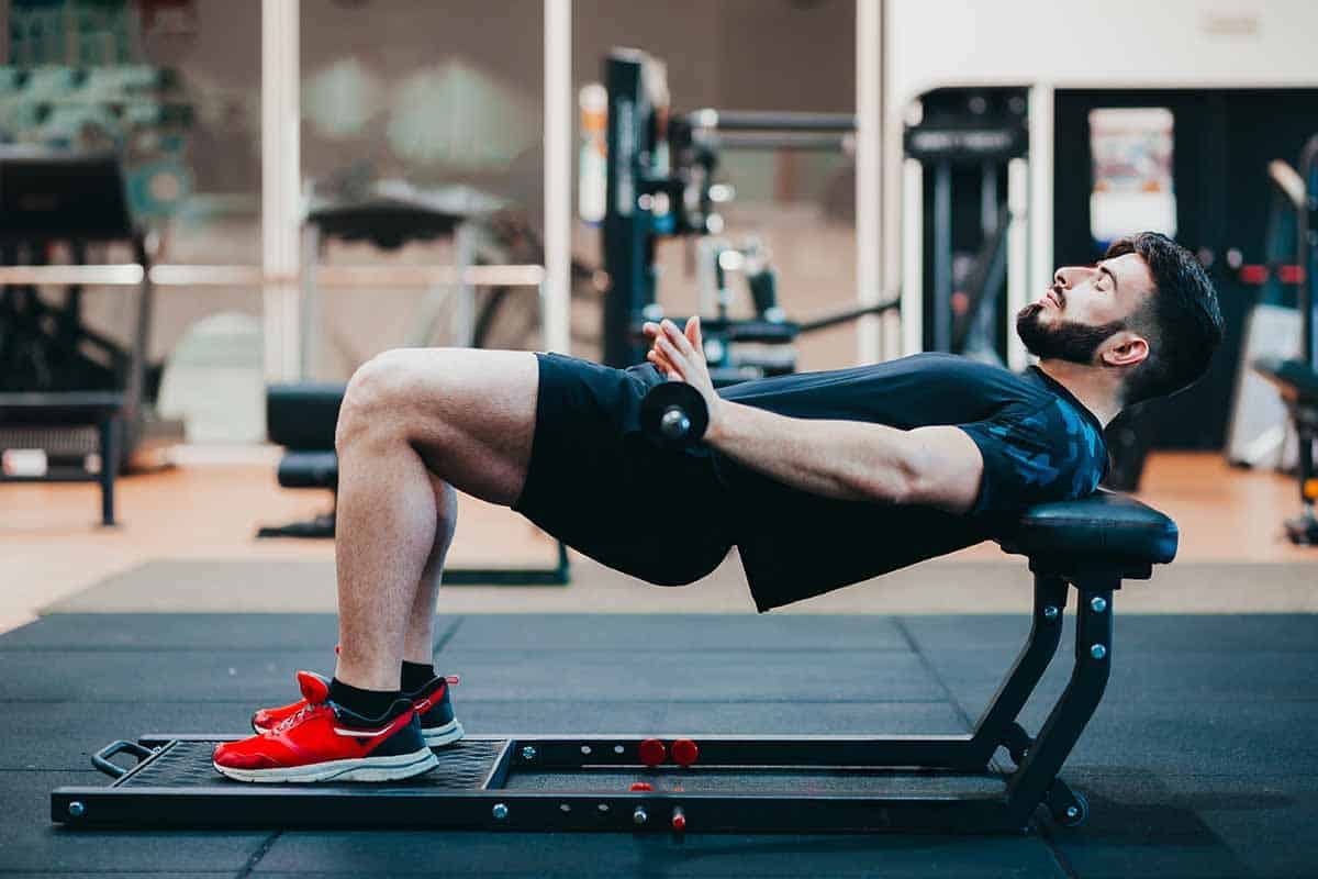 Man training Hip Thrust exercise at gym - what is the difference between Kas Glute Bridge vs Hip Thrust