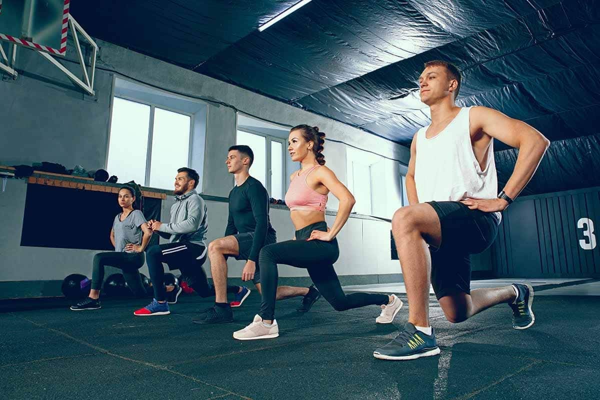 Group of people doing lunge at gym