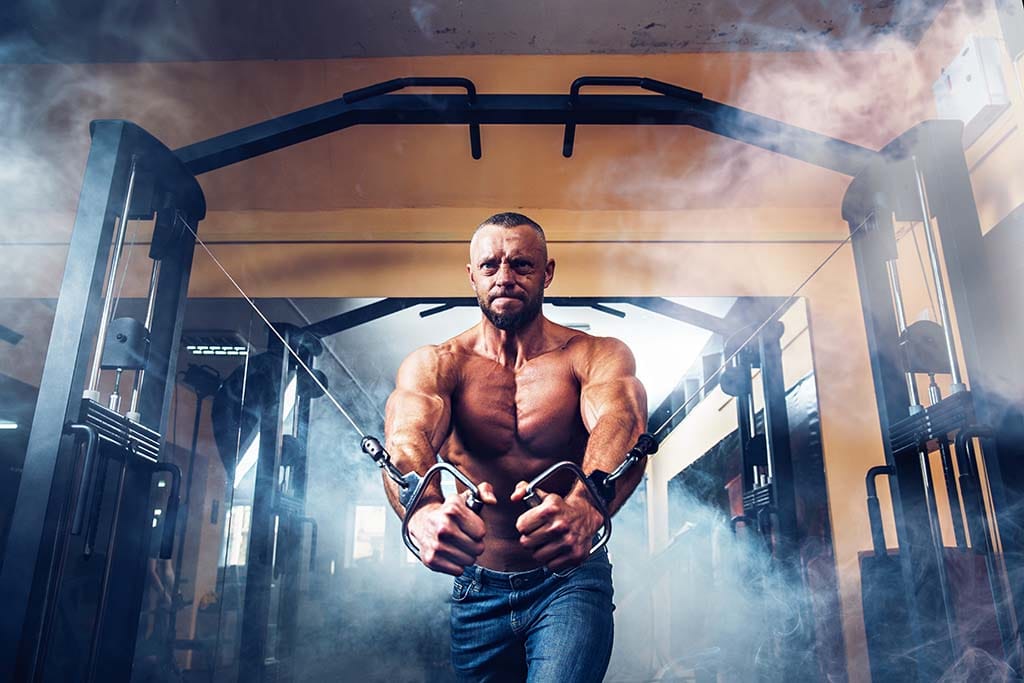 Man doing lower body cable chest workout at gym