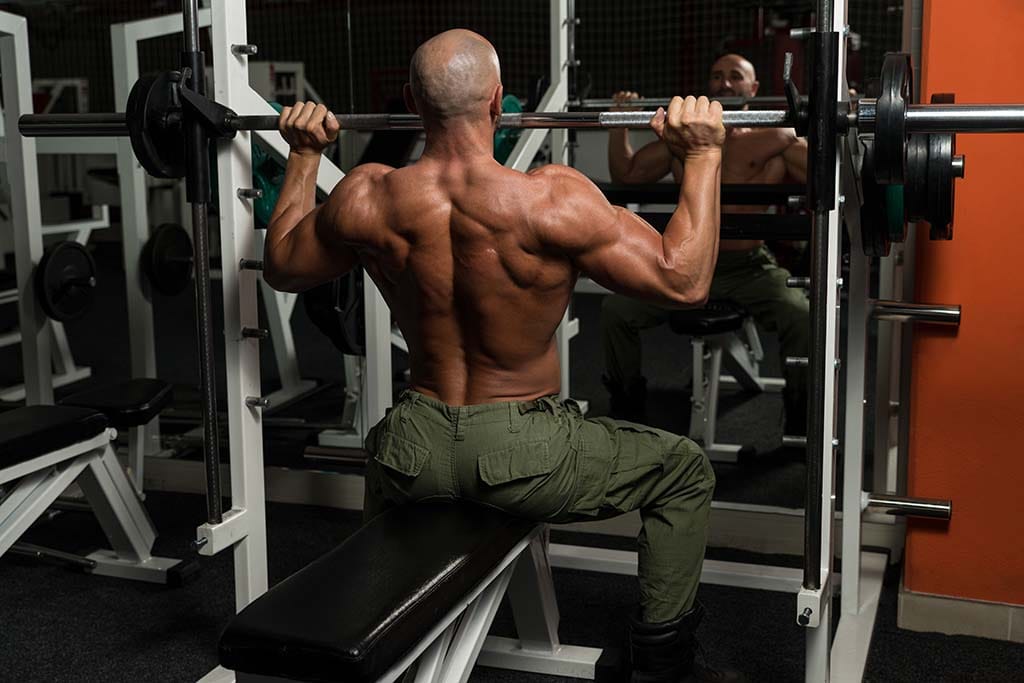 Bodybuilder exercising with Smith machine