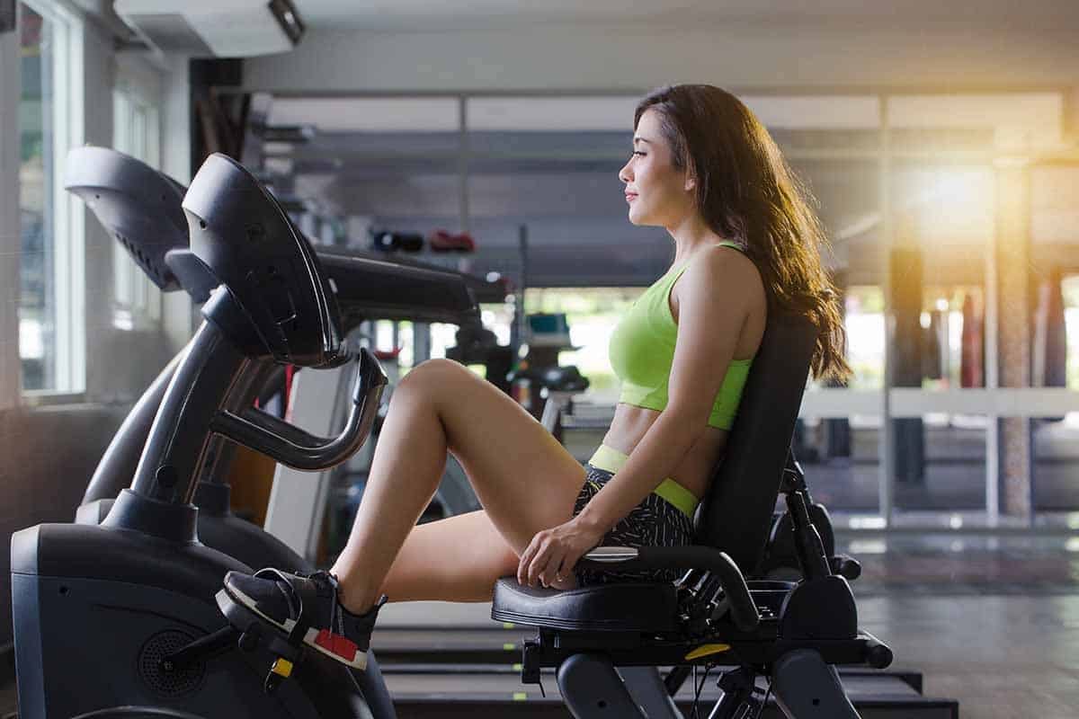 the woman is exercise legs on a recumbent bike in the gym