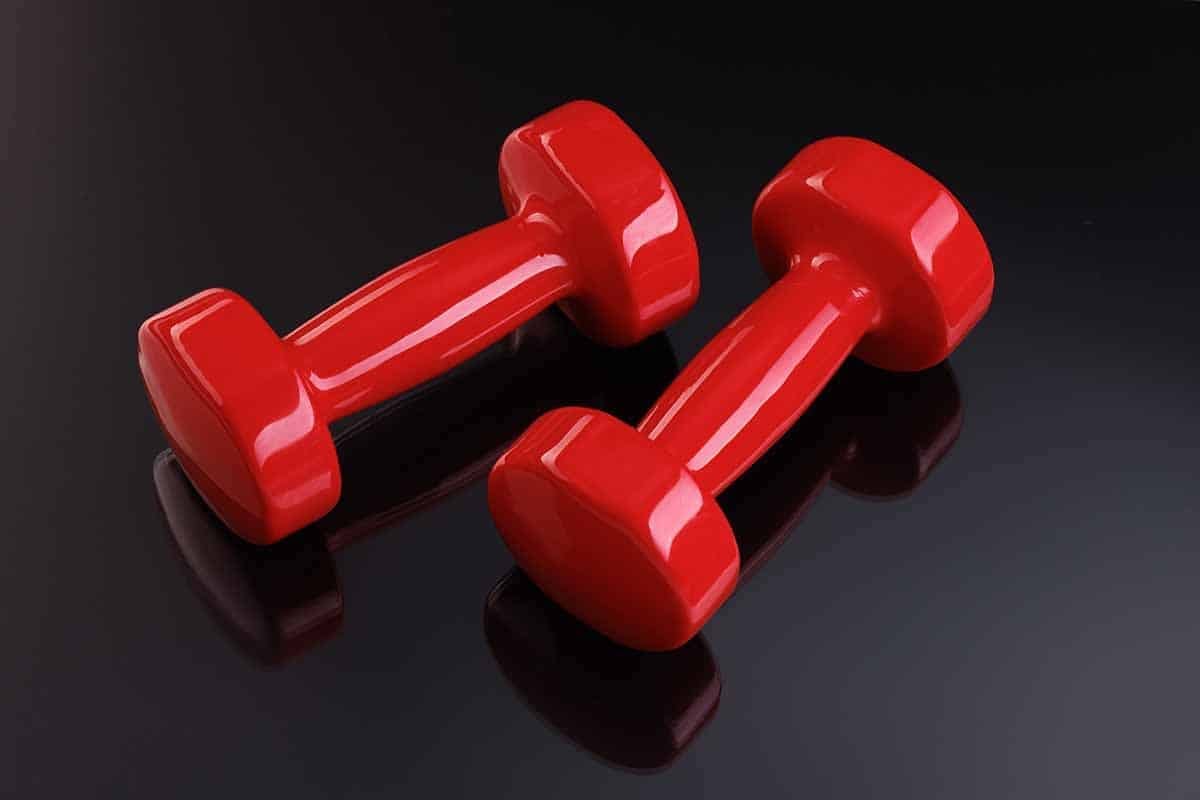 a pair of red Vinyl Dumbbells on black background