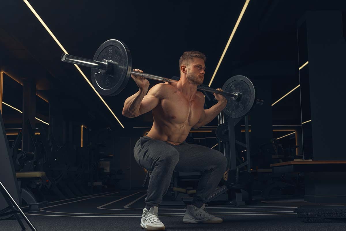 Man doing barbell squats.