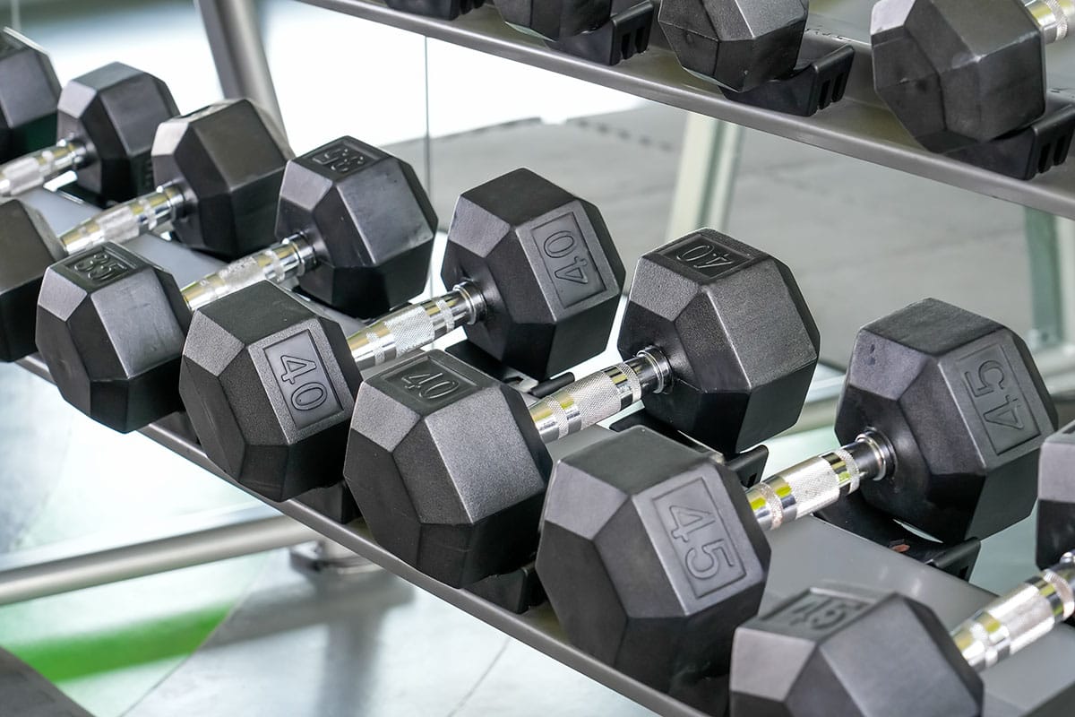 Increasing dumbbell weights represent progressive overload